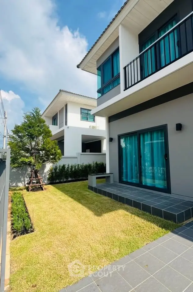 Modern two-story house with spacious garden and balcony, perfect for family living.