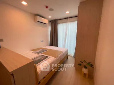 Cozy bedroom with modern decor and natural light in a stylish apartment.