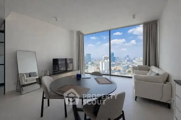Modern living room with panoramic city view, sleek furniture, and large windows in a high-rise apartment.