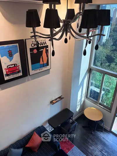 Stylish loft living room with high ceilings, modern chandelier, and large windows offering scenic views.