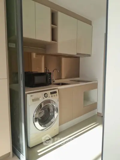 Modern kitchen with washing machine and sleek cabinetry