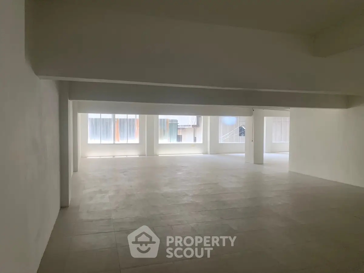 Spacious open-plan interior with large windows and ample natural light.