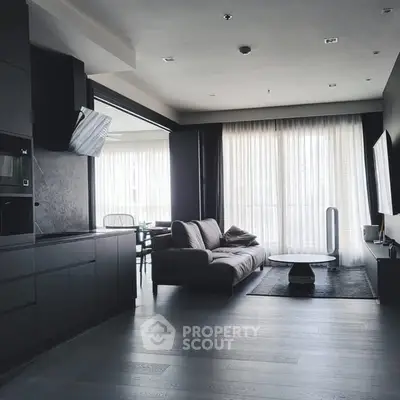 Modern living room with sleek black kitchen and large windows