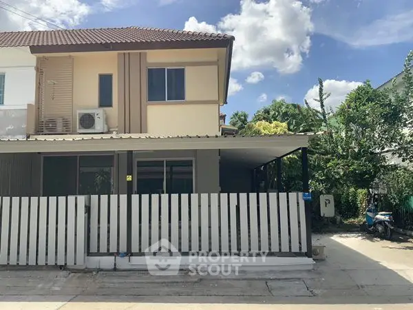 Charming two-story house with modern facade and fenced yard in a serene neighborhood.