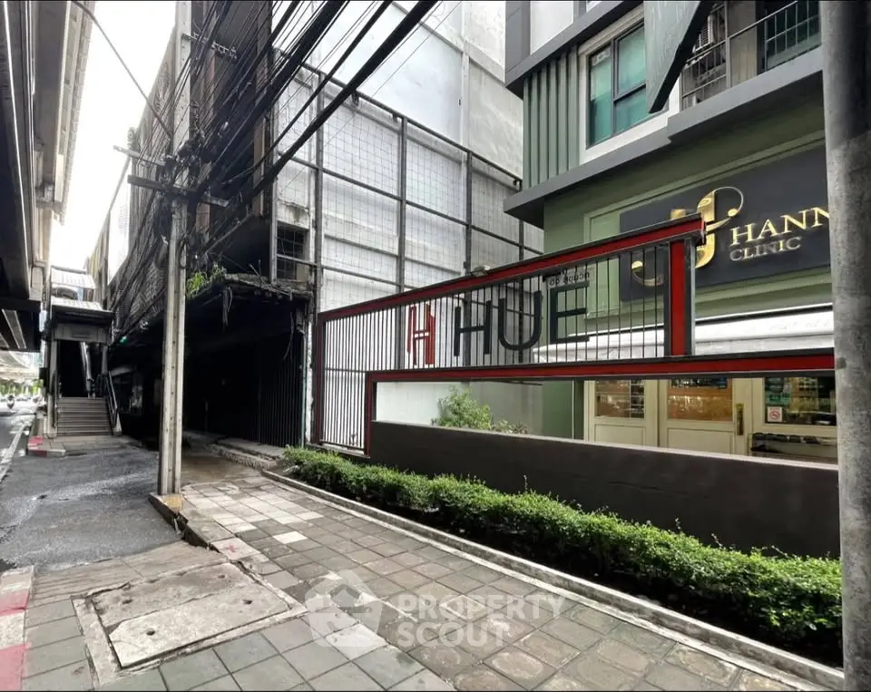 Modern urban building exterior with sidewalk and clinic signage, showcasing contemporary architecture.