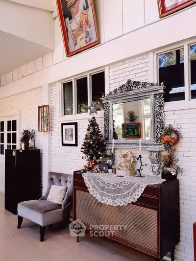 Charming living room with elegant decor, featuring a vintage mirror, festive Christmas tree, and cozy seating.