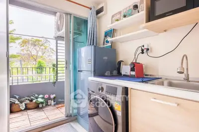Charming compact kitchen with balcony view, featuring modern appliances and cozy decor.