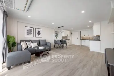 Spacious modern living room with open kitchen, stylish decor, and natural light.