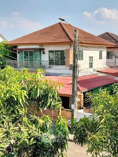 Charming suburban house with tiled roof and lush greenery, perfect for family living.