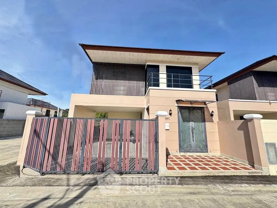 Modern two-story house with gated entrance and stylish facade in a sunny neighborhood.