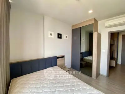 Modern bedroom with stylish decor and mirrored wardrobe in a cozy apartment.