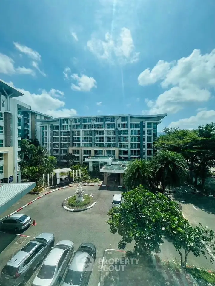 Stunning view of modern residential building with lush greenery and ample parking space.