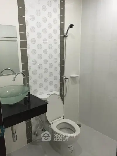 Modern bathroom with stylish glass sink and shower area