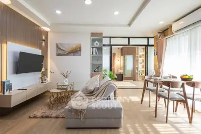 Modern living room with elegant decor and open dining area, featuring stylish furniture and natural lighting.