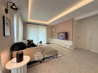 Modern living room with stylish decor and ambient lighting, featuring a cozy sofa and wall-mounted TV.