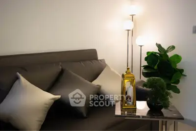 Stylish living room with modern sofa, elegant lighting, and chic decor accents.