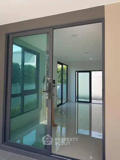 Modern interior with large glass doors and sleek tile flooring, perfect for natural light lovers.