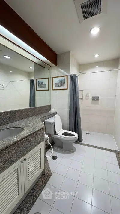 Modern bathroom with sleek design, featuring a spacious shower and elegant vanity.