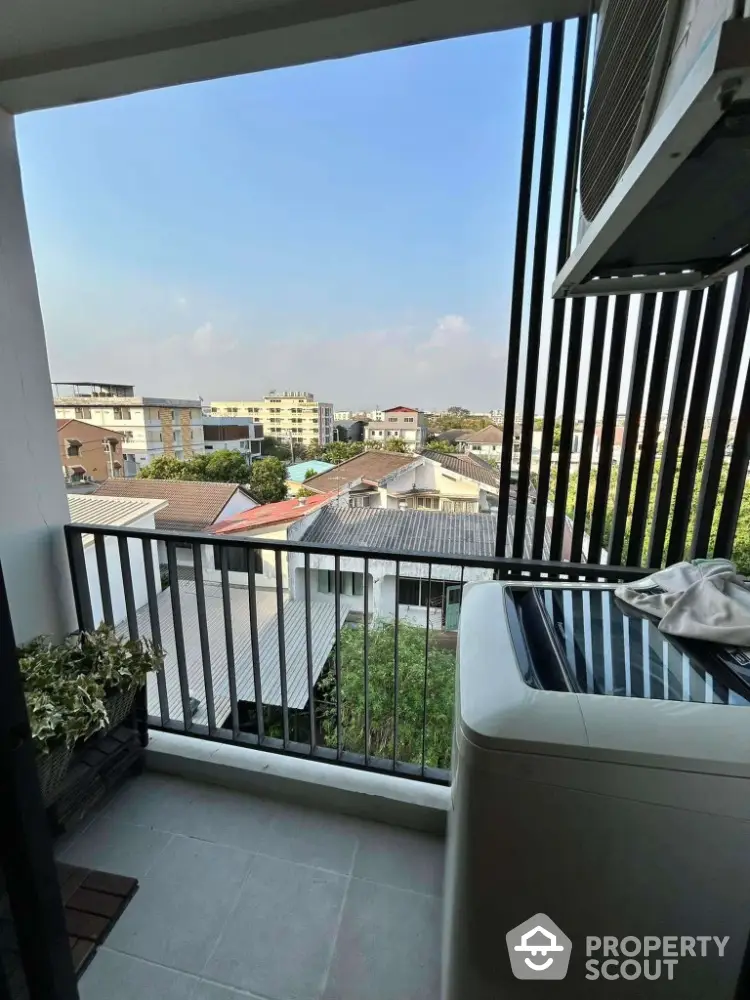 Charming balcony with city view and modern washing machine, perfect for urban living.