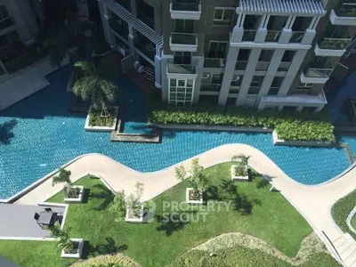 Luxurious residential building with stunning pool and landscaped garden view from above.