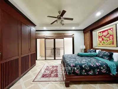 Luxurious bedroom with elegant wooden accents and floral bedding in a spacious layout.