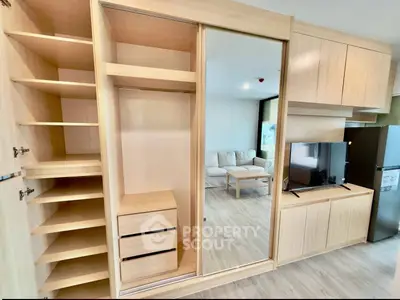 Modern apartment interior with built-in wooden wardrobe and cozy living area.
