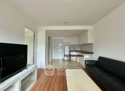 Modern living room with open kitchen layout and sleek furnishings