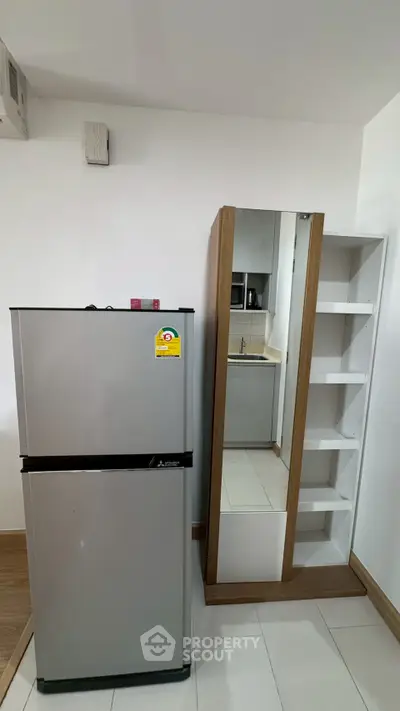 Modern kitchen corner with sleek fridge and storage shelves