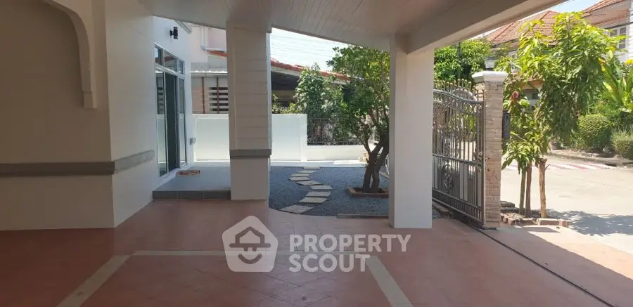 Spacious covered entrance with tiled flooring and garden view