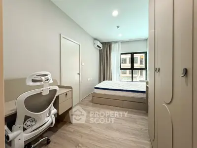 Modern bedroom with sleek furniture and natural light, featuring a comfortable bed and ergonomic chair.