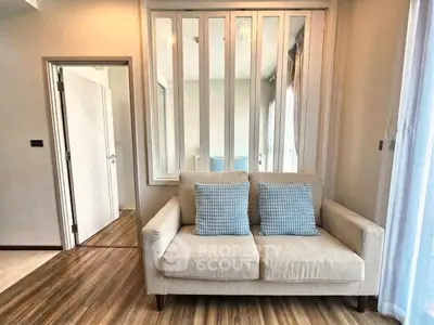 Chic living room with stylish sofa and elegant wooden flooring, perfect for modern urban living.