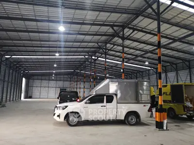 Spacious industrial warehouse with high ceilings and ample parking space.