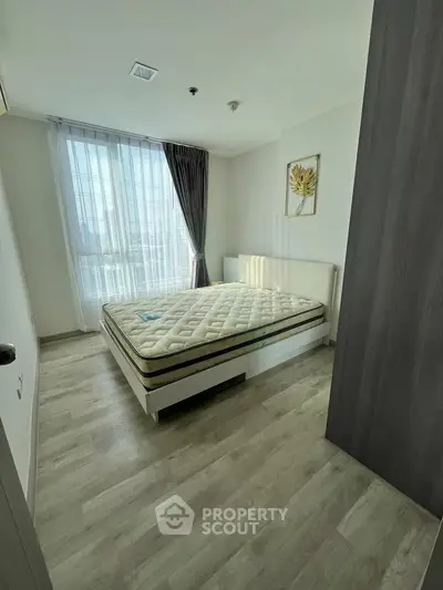 Modern bedroom with large window and stylish decor in a bright apartment