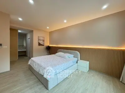 Spacious modern bedroom with elegant lighting and cozy decor