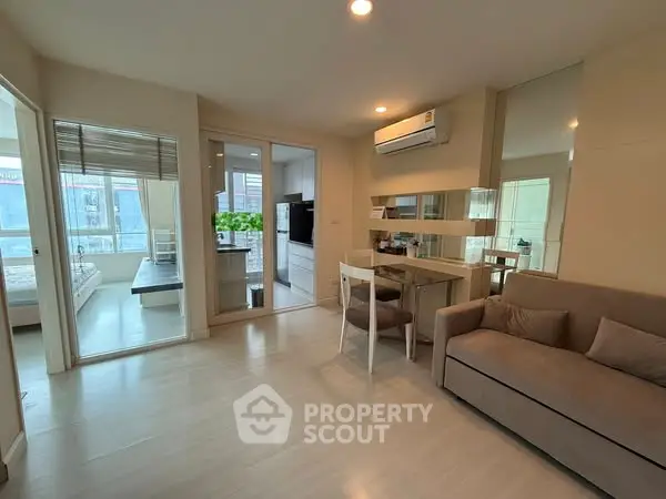 Modern living room with sofa, dining area, and air conditioning in a bright apartment.