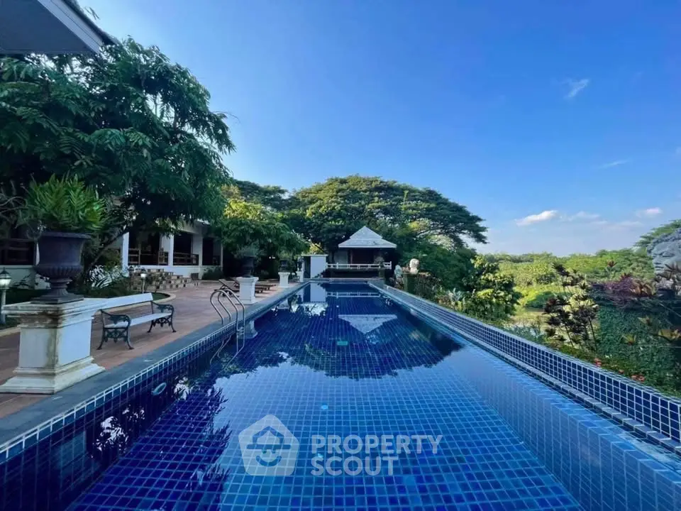 Luxurious outdoor pool with stunning garden view and elegant surroundings.