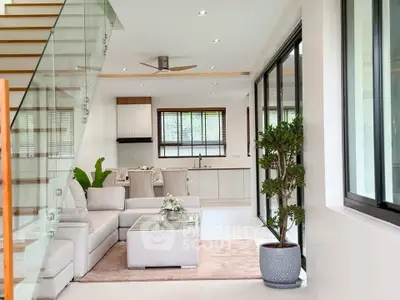 Spacious modern living room with open kitchen and elegant staircase in a luxury home.