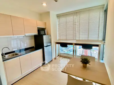Modern kitchen with open layout and city view, featuring sleek cabinetry and breakfast bar.