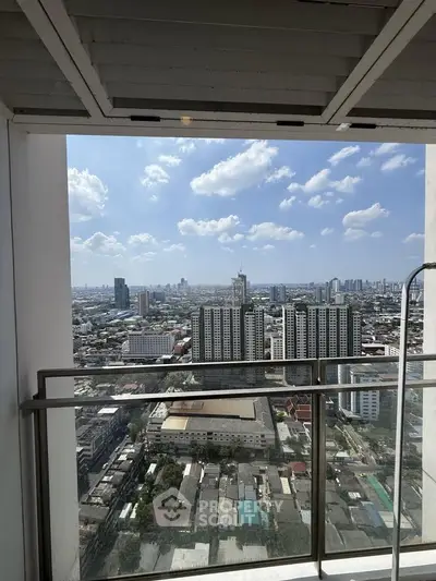 Stunning cityscape view from a high-rise balcony with clear blue skies and modern urban skyline.