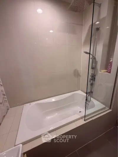 Modern bathroom with sleek bathtub and glass shower partition