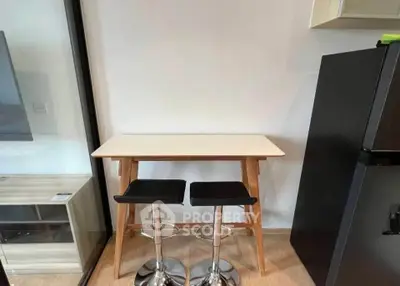 Modern kitchen nook with sleek bar stools and compact fridge