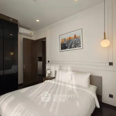 Modern bedroom with sleek design, featuring a cozy bed, stylish lighting, and contemporary artwork.