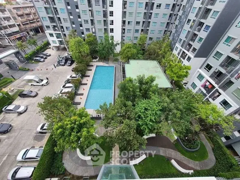 Stunning aerial view of modern apartment complex with pool and lush greenery