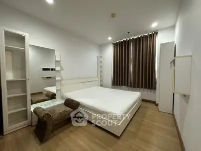 Modern minimalist bedroom with sleek white furniture and wooden flooring