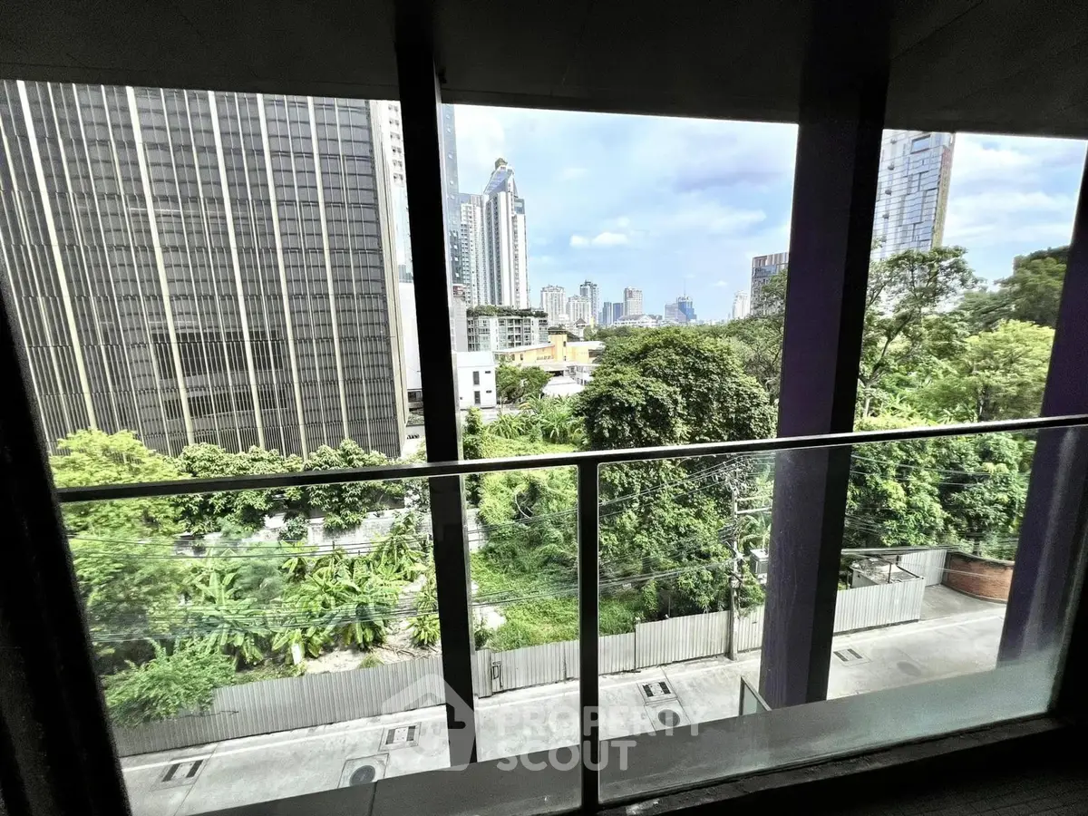 Stunning cityscape view from a modern balcony with lush greenery and skyscrapers.