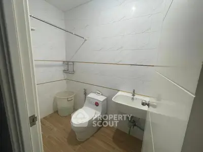 Modern bathroom with sleek white fixtures and tiled walls