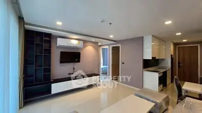 Modern living room with sleek design and open kitchen layout in a stylish apartment.