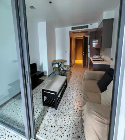 Modern living room with open kitchen and cozy seating area in a stylish apartment.