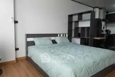 Modern bedroom with stylish shelving and cozy bedding in a contemporary apartment.