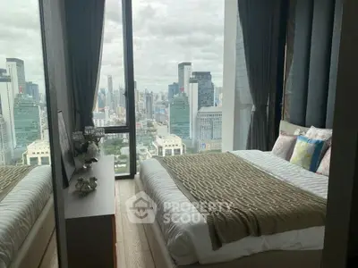 Luxurious bedroom with stunning city view from floor-to-ceiling windows in a high-rise apartment.